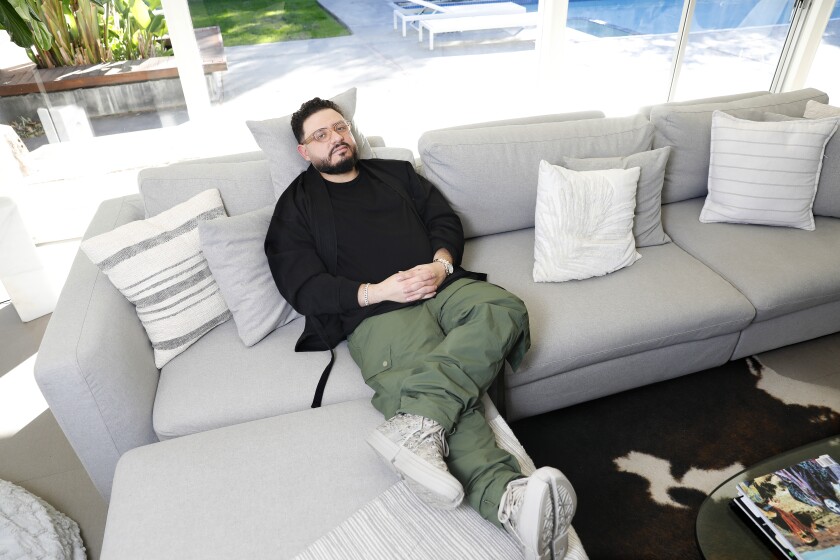 A man sitting on a sectional sofa.