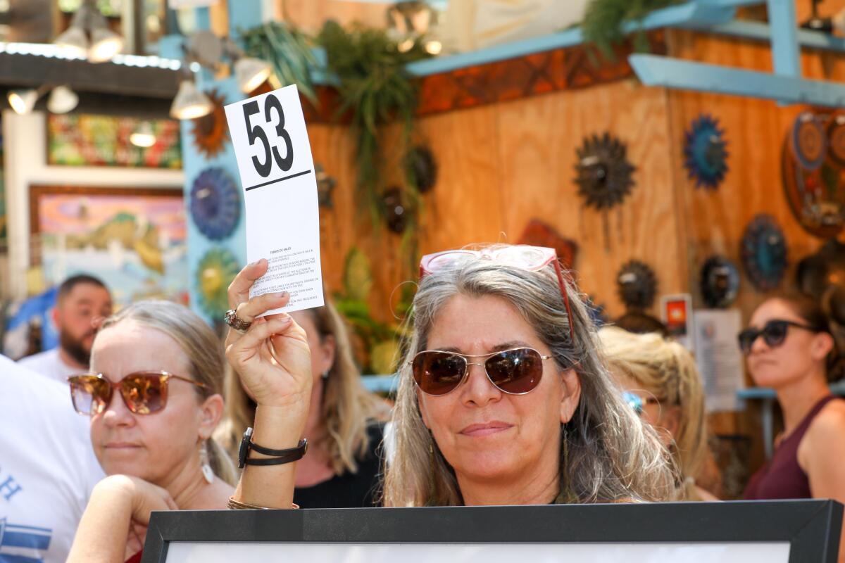 A patron bids on art during an auction for the Sawdust Art Festival's Artists' Benevolence Fund on Aug. 14.