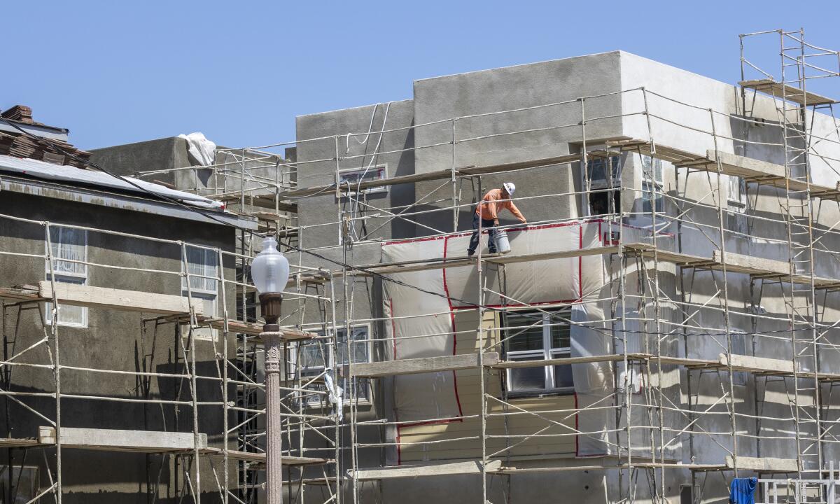 A worker works on scaffolding constructing a new home in The Great Park Neighborhoods in Irvine.