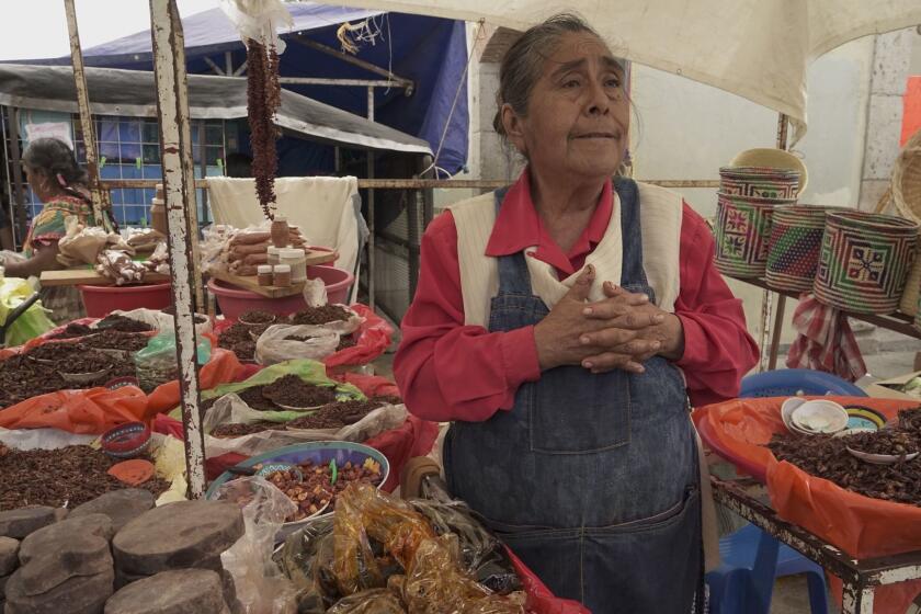 Eufenia Hernandez, 63, sells goods from her stall at the Sunday market in Tlacolula, Mexico.