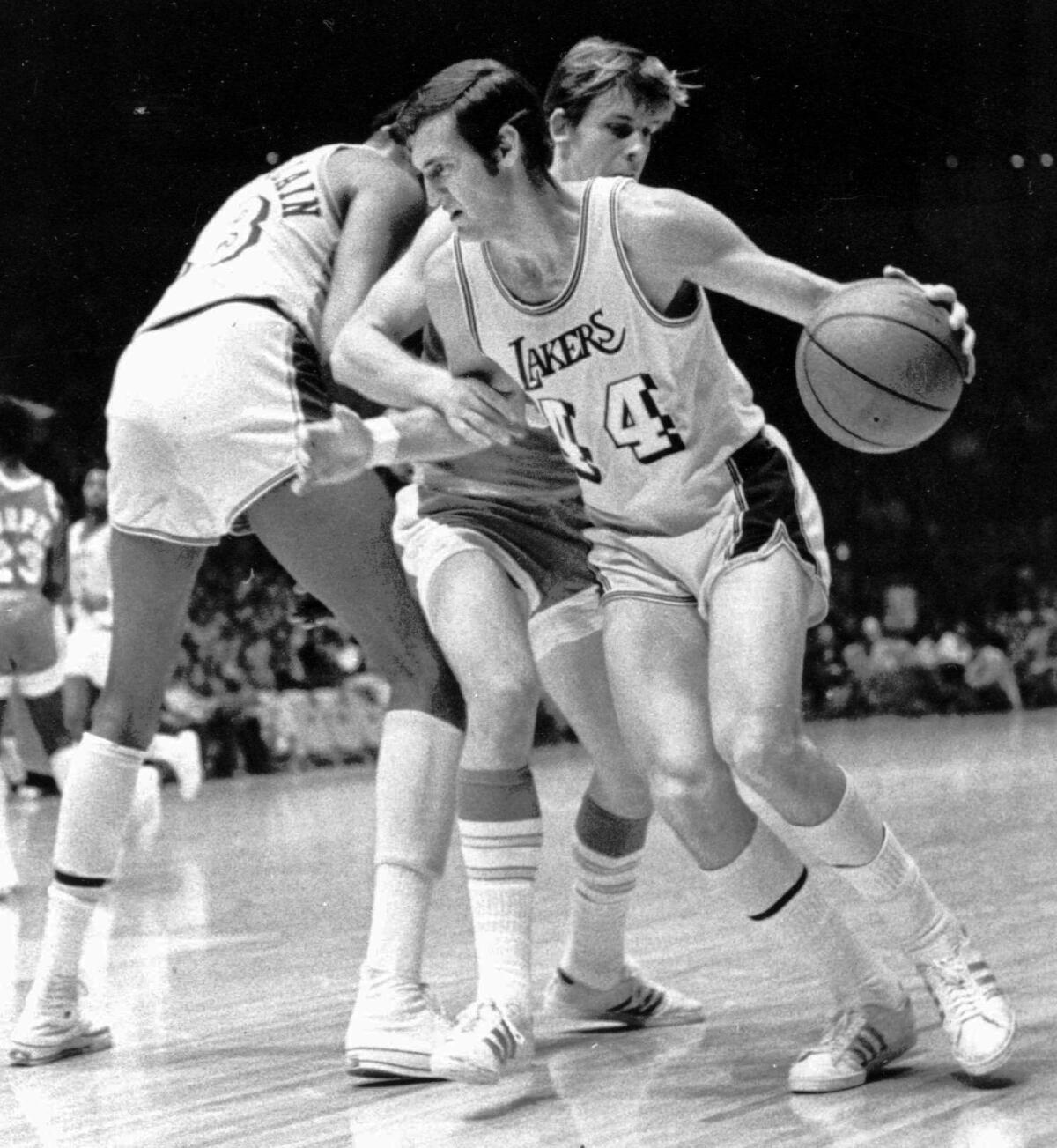 Lakers guard  Jerry West (14) is fouled as he tries to get around Rockets guard John Vallely.