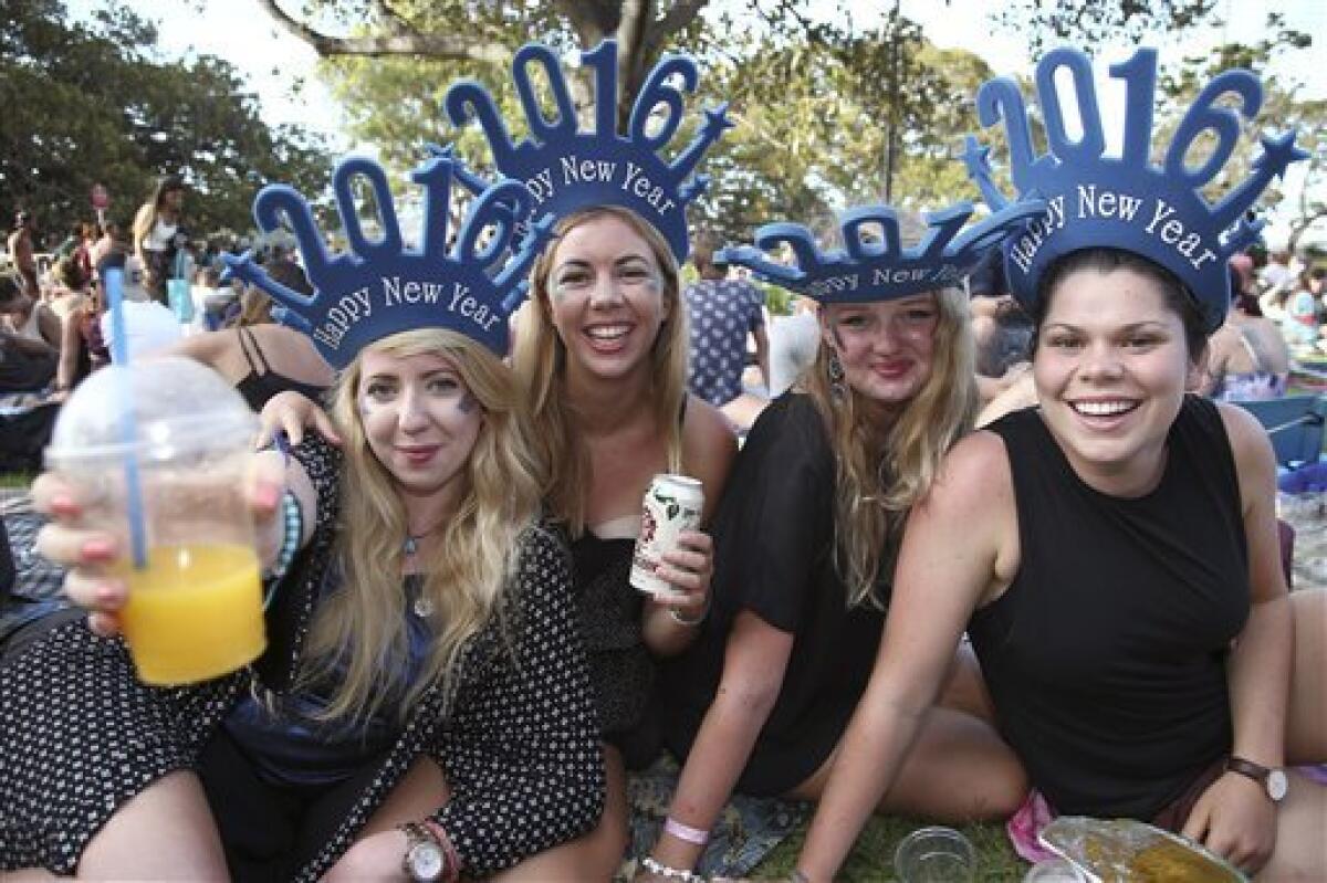 Un grupo de mujeres celebra la llegada de 2016 mientras esperan el inicio del tradicional espectáculo pirotécnico de Año Nuevo en Sydney, Australia, el 31 de diciembre de 2015. (Foto AP/Rob Griffith)