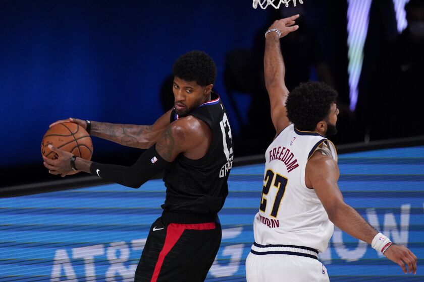 Los Angeles Clippers' Paul George (13) grabs a rebound in front of Denver Nuggets' Jamal Murray (27) during the second half of an NBA conference semifinal playoff basketball game Saturday, Sept. 5, 2020, in Lake Buena Vista, Fla. (AP Photo/Mark J. Terrill)