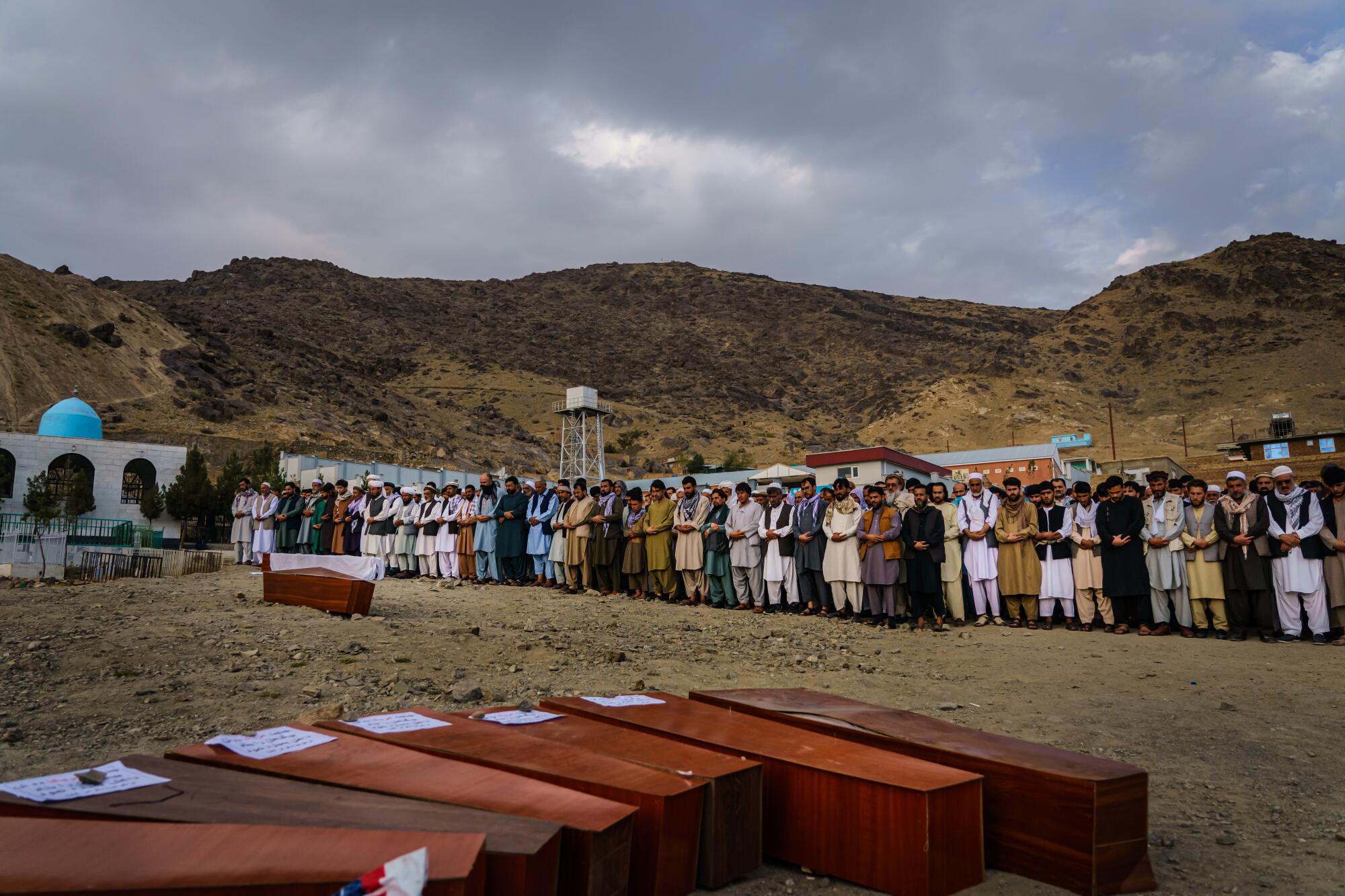 The caskets of the blast victims are lined up as Islamic prayers are recited Monday.