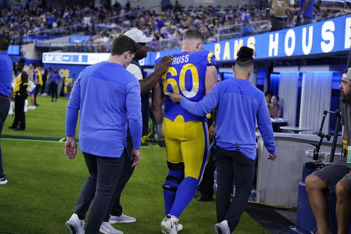 Rams guard Logan Bruss is helped off the field after sustaining a season-ending injury in his first NFL preseason game.