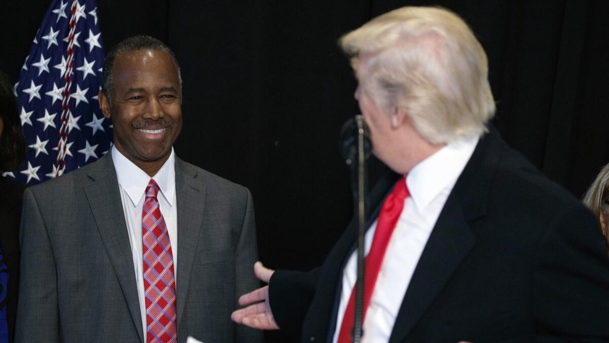 Dr. Ben Carson, left, listens as President Trump speaks after touring the National Museum of African American History and Culture in Washington in February 2017.