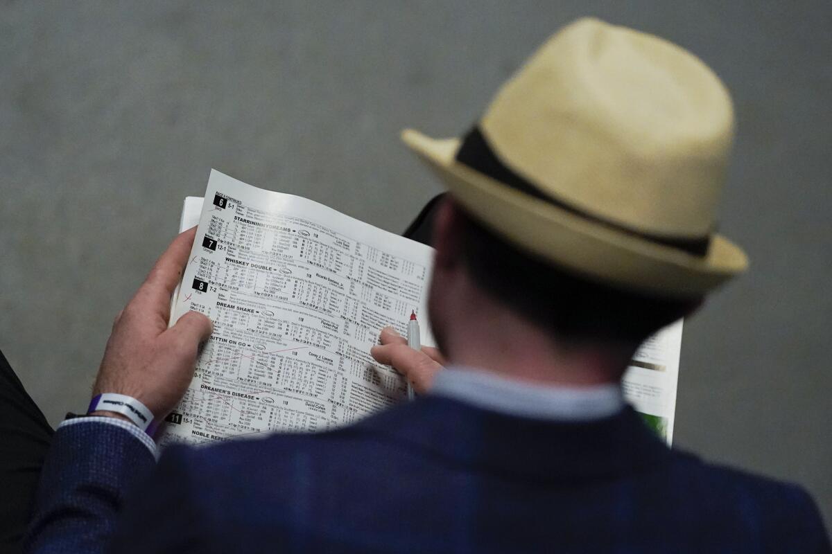 A man looks at a racing program before the 147th running of the Kentucky Derby at Churchill Downs on Saturday.