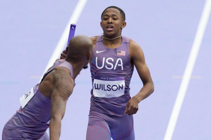 Quincy Wilson, of the United States, hands over the baton to teammate Vernon Norwood.