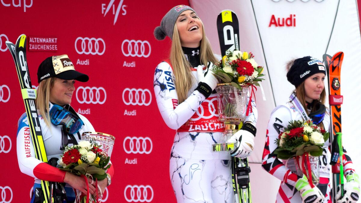 Lindsey Vonn takes her place atop the podium, flanked by runner-up Lara Gut, left, and third-placer Cornelia Huetter, on Sunday.