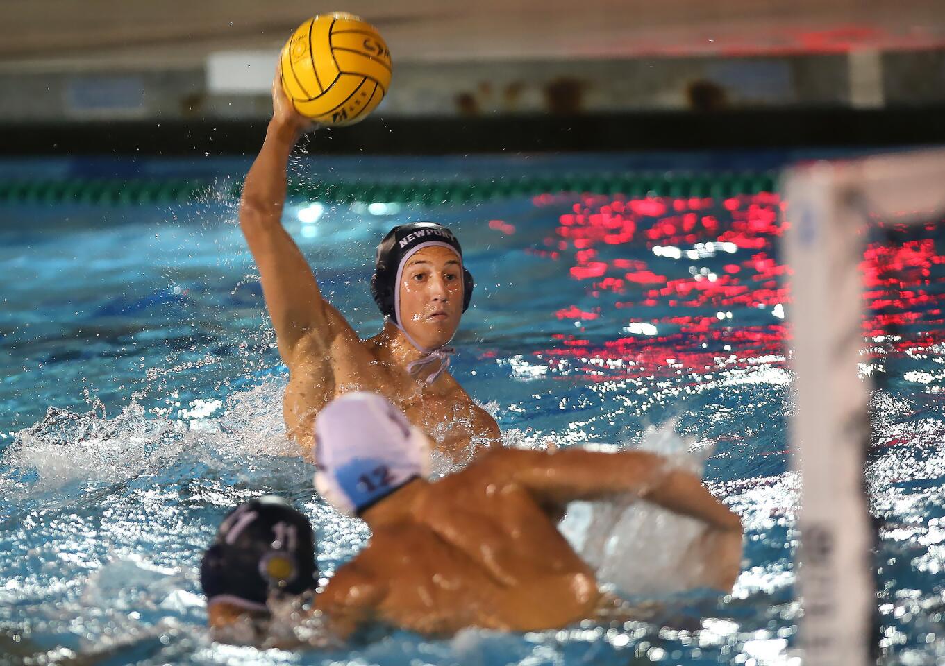 Newport Harbor High's Jack White prepares to fire the ball for a goal during Surf League water polo match against Laguna Beach, at Corona del Mar High on Wednesday.