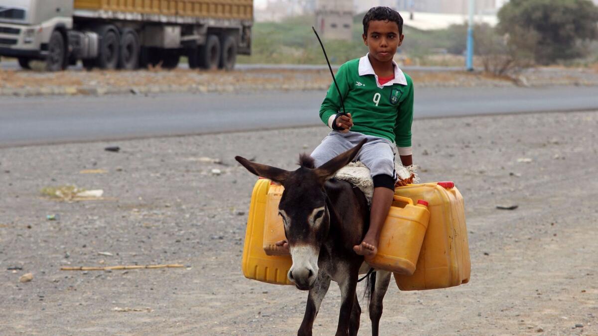 A Yemeni boy rides a donkey carrying plastic containers full of water in an impoverished coastal village on the outskirts of the Yemeni port city of Hudaydah last month.