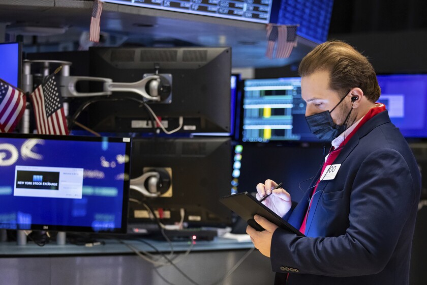 In this photo provided by the New York Stock Exchange, trader Ben Tuchman works on the floor, Friday, Jan. 28, 2022. Stocks rose in afternoon trading on Wall Street Friday, potentially trimming losses for some of the major indexes this week. (Allie Joseph/New York Stock Exchange via AP)
