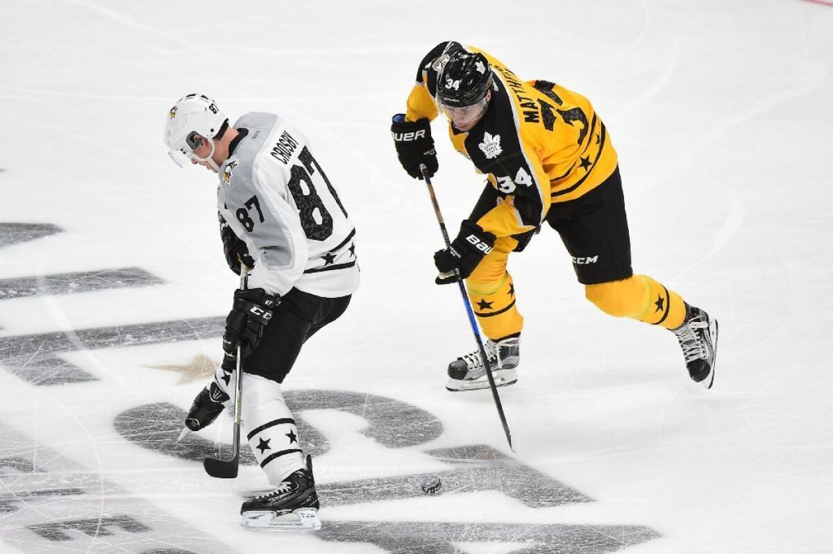 Pittsburgh Penguins center Sidney Crosby, left, and Toronto Maple Leafs center Auston Matthews battle for the puck during the 2017 NHL All-Star Game at Staples Center on Sunday.