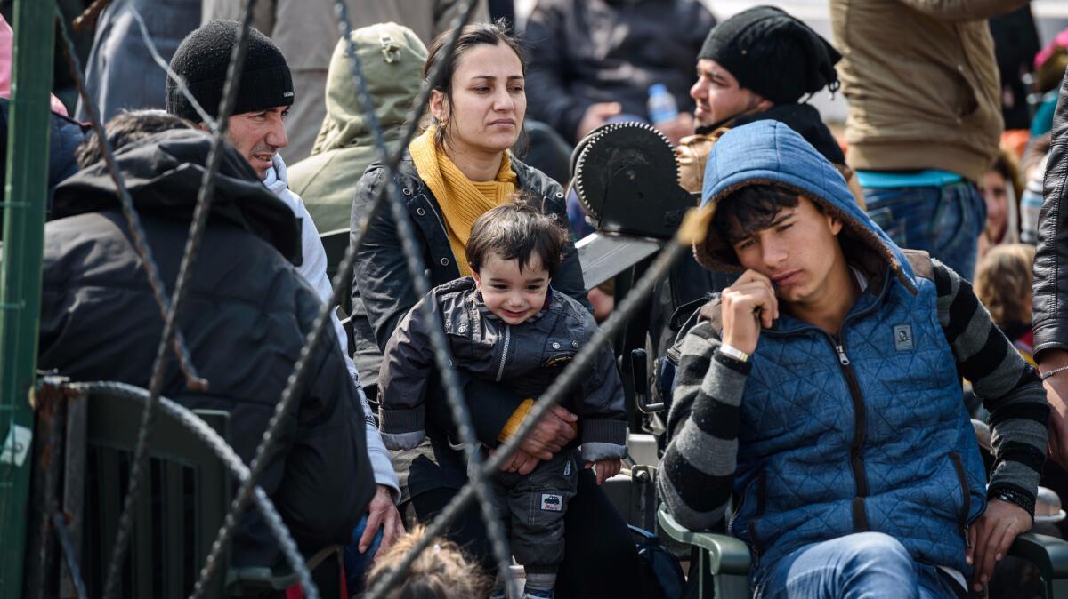 Migrants wait at a Turkish coast guard station at the Dikili district in Izmir on March 20, 2016, after they were caught trying to reach the Greek island of Lesbos from the Bademli village, western Turkey.