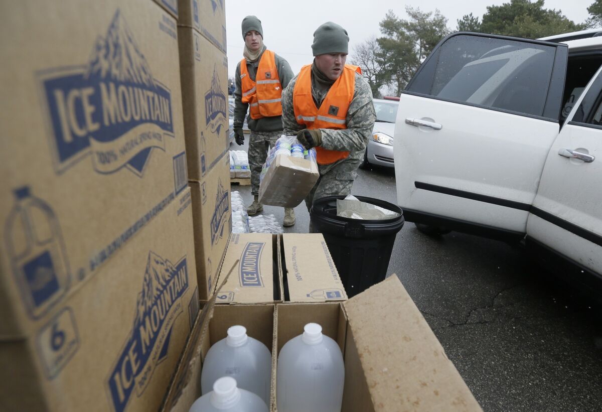 Members of the Michigan National Guard load bottled water at a fire station on Jan. 28 in Flint, Mich.