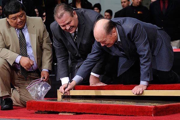 Signing his name, Academy Award-winning actor Robert Duvall makes his mark during the traditional hand-and-foot imprint ceremony to celebrate Duvall's 50 years in the film industry.