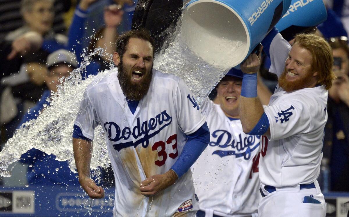 Scott Van Slyke is doused by teammate Justin Turner after hitting a walk-off home run against Miami on May 11.