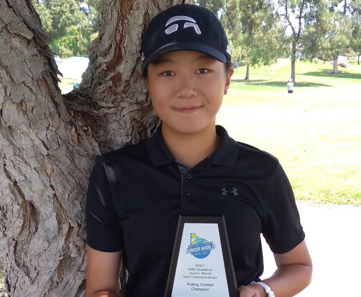 XinZhu Wu holds the plaque she won in a putting contest before shooting a 3-over 75 Tuesday.