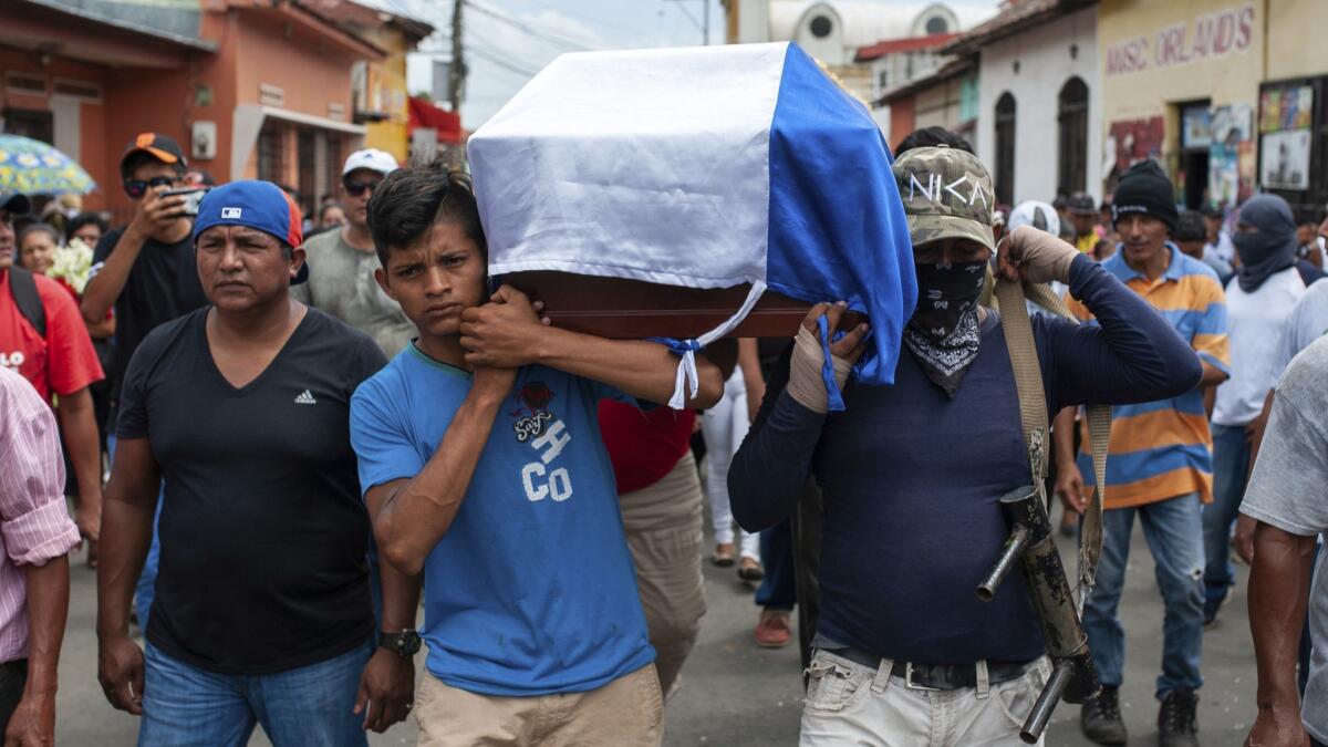 Friends and family on Monday carry a coffin holding the body of Jose Esteban Sevilla Medina, who was shot at a barricade during an attack by police and paramilitary forces, in Masaya, Nicaragua. Pro-government forces continued armed operations in the city on Tuesday.
