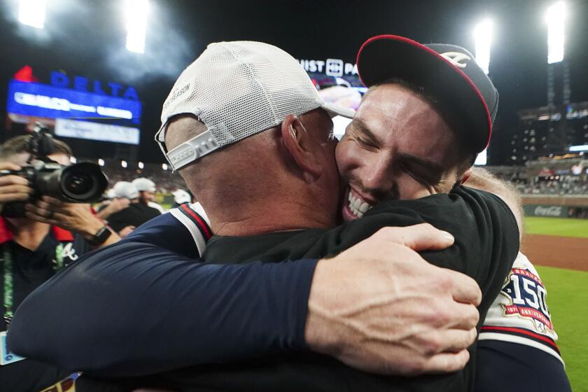 Atlanta Braves Freddie Freeman embraces Atlanta Braves manager Brian Snitker after Game 4 of a baseball National League Division Series against the Milwaukee Brewers, Tuesday, Oct. 12, 2021, in Atlanta. The Atlanta Braves won 5-4 to advance to the NLCS. (AP Photo/John Bazemore)