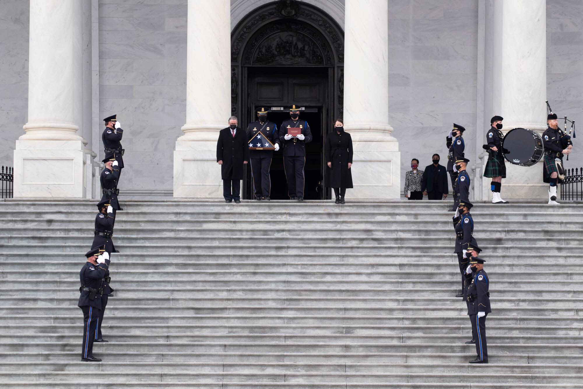 Sicknick's remains are carried down the East Front steps