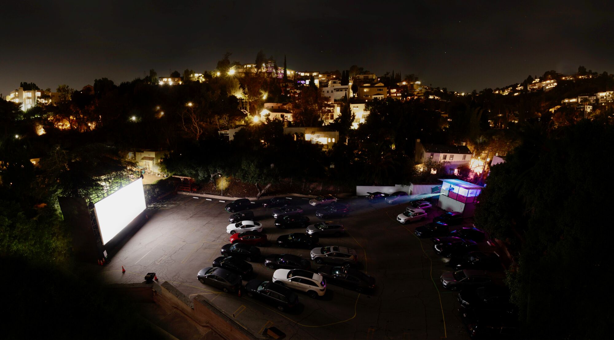 A view from above of cars parked in front of an outdoor movie screen