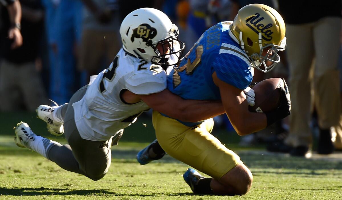 UCLA's Nate Meadors, right, is tackled by Colorado's Nelson Spruce in the fourth quarter at Rose Bowl on Saturday.