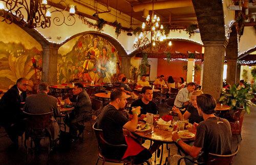 La Huasteca diners eat lunch under wrought-iron chandeliers.