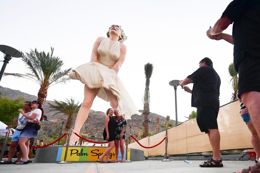 People visit the "Forever Marilyn" statue on its return to Palm Springs, California on June 20, 2021. 