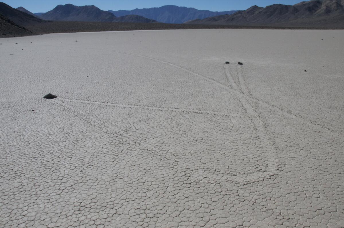 Moving rocks mysteriously snake across a dry lakebed at Death Valley national park.
