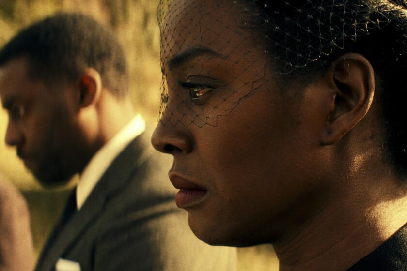 A woman, eyes welling with tears, at a funeral 