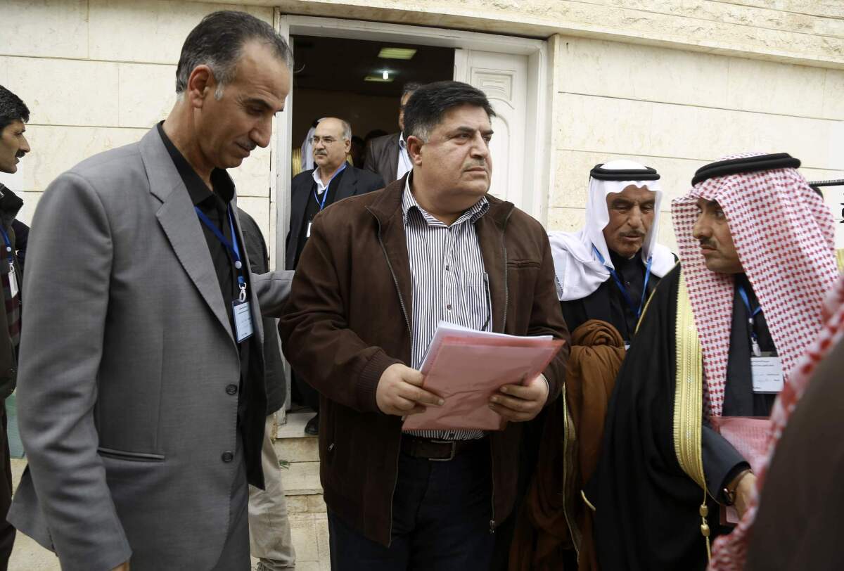 Amer Halloush, center, of the Syrian Democratic Council, the political branch of a Kurdish-Arab fighting force, leaves after a meeting of more than 150 delegates from Kurdish, Arab, Assyrian and other parties in Syria's northeastern Hassakeh province.