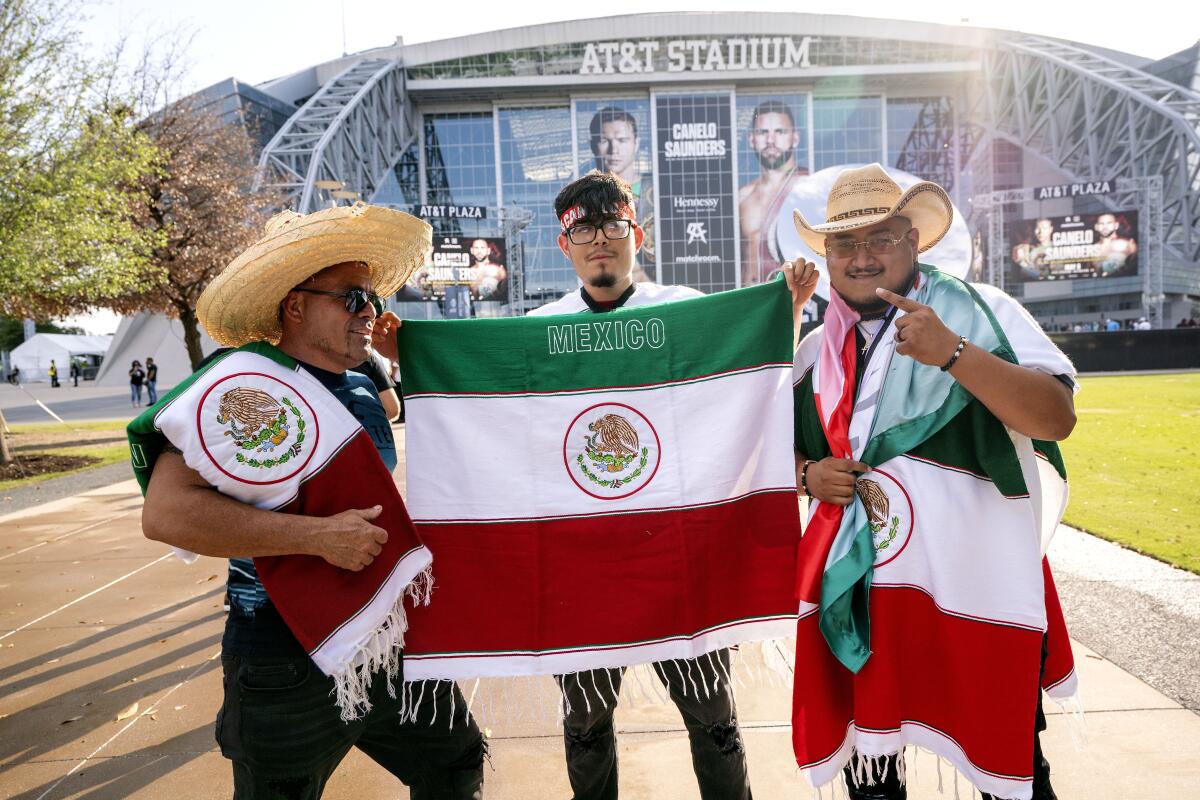 Boxing fans pose with Mexican flags outside AT&T Stadium before the Canelo Álvarez vs. Billy Joe Saunders fight