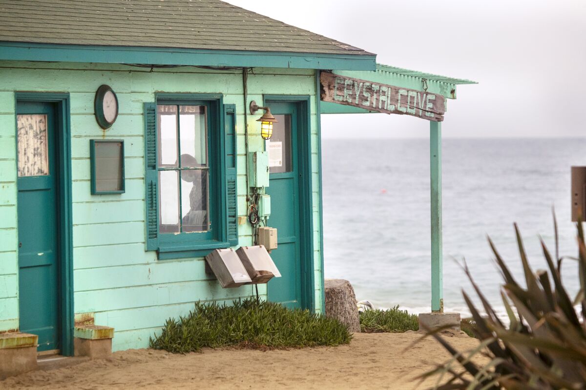 A man explores the interior of a historic cottage on the beach at Crystal Cove State Beach.