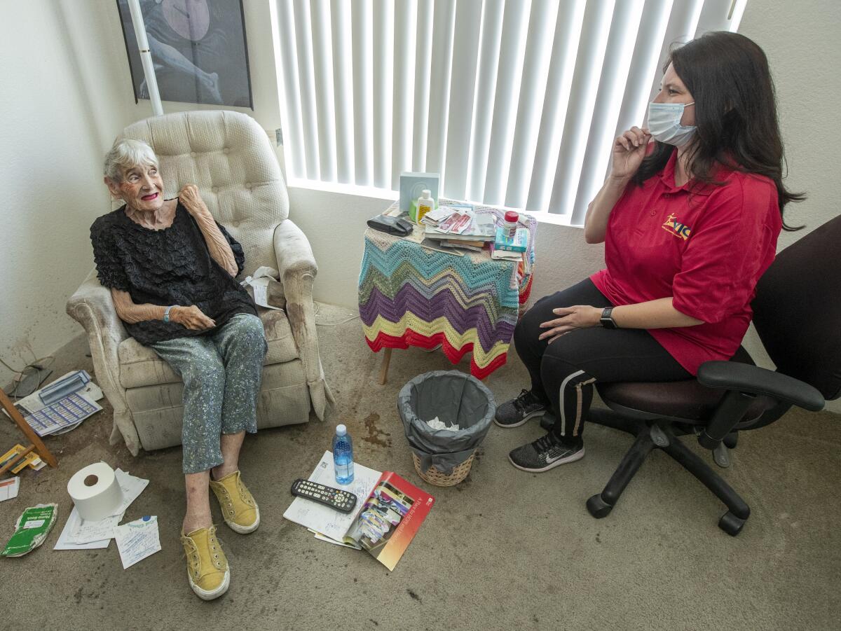 Joan Chester who lives alone inside her apartment in North Hollywood, sits with Karen Kochara.