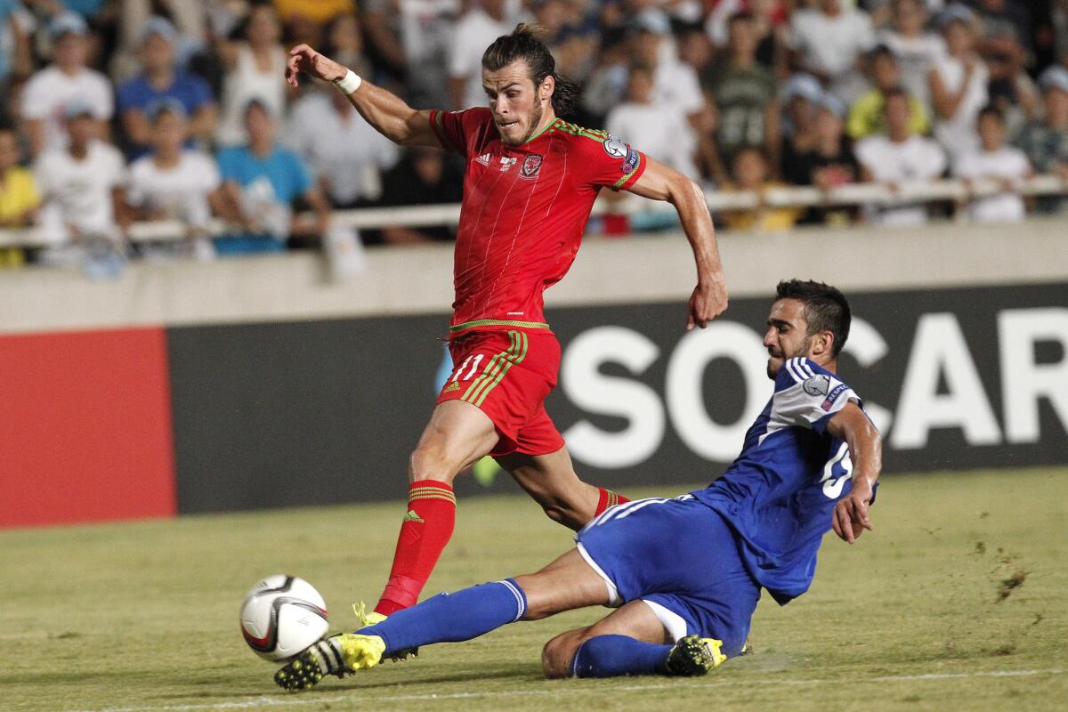 Cyprus' Kosta Laifis, right, challenges Wales' Gareth Bale for the ball during the Euro 2016 qualifying Group B match between Cyprus and Wales, at GSP stadium, in Nicosia, Cyprus, Thursday, Sept. 3, 2015. (AP Photo/Petros Karadjias)