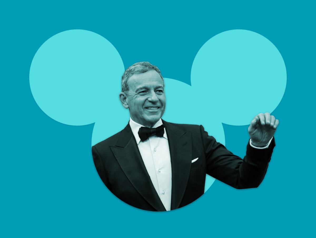 a man in a tux waves from inside the silhouette of the Disney mouse icon