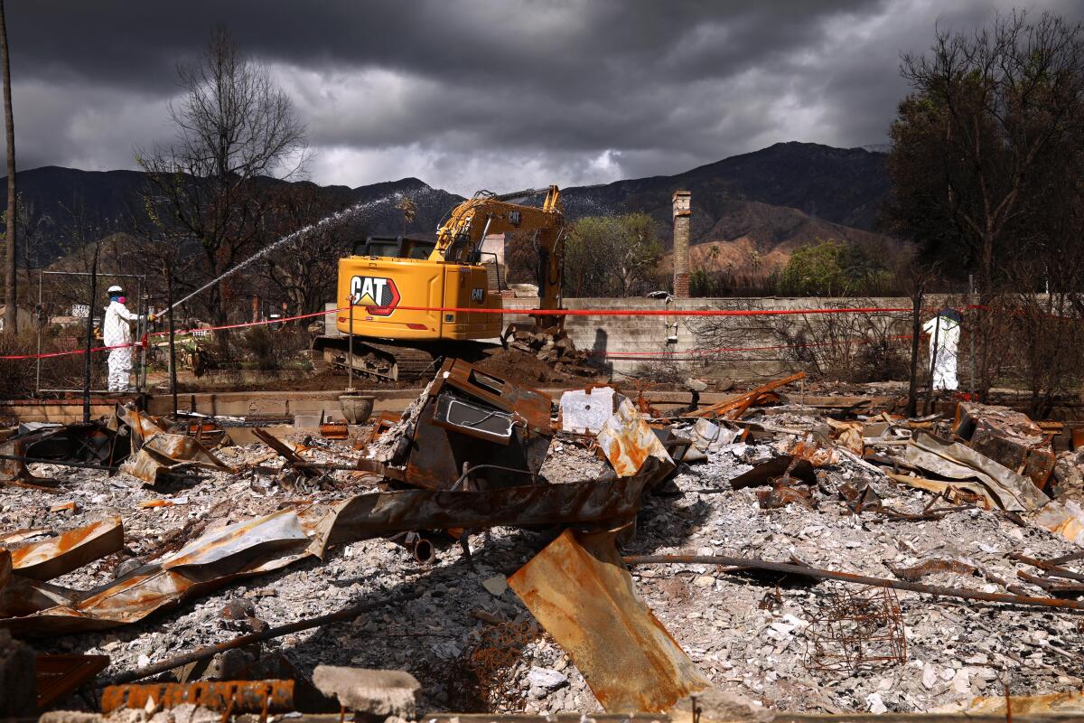 A tractor moves debris from a fire.