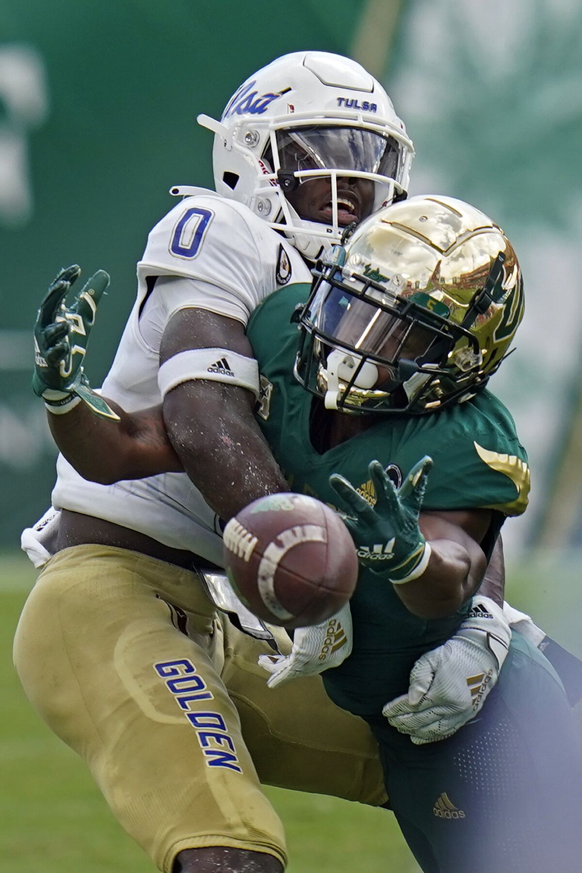 South Florida wide receiver Jimmy Horn Jr. (5) loses the football after getting hit by Tulsa cornerback Tyon Davis (0) during the second half of an NCAA college football game Saturday, Oct. 16, 2021, in Tampa, Fla. (AP Photo/Chris O'Meara)