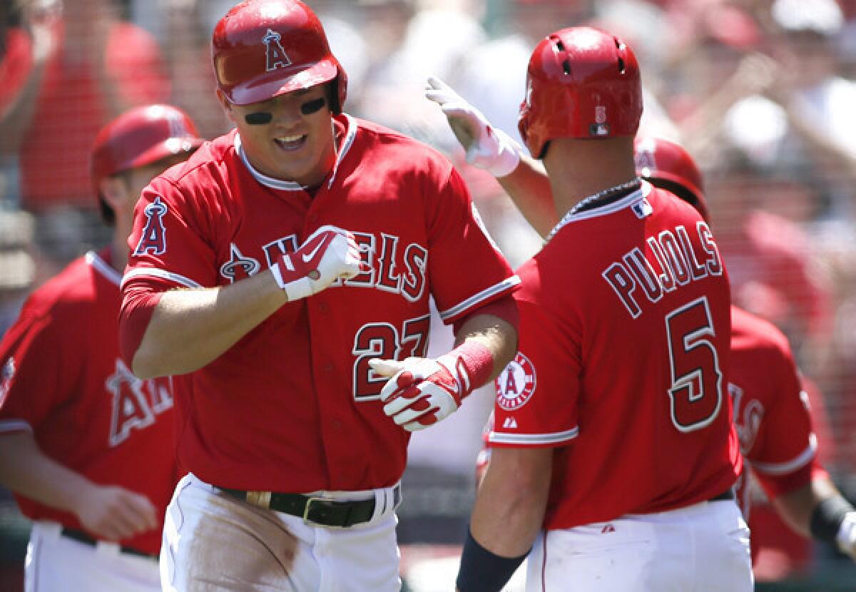 Angels left fielder Mike Trout is congratulated by first baseman Albert Pujols after hitting a grand slam against the Tigers in the first inning Saturday afternoon.