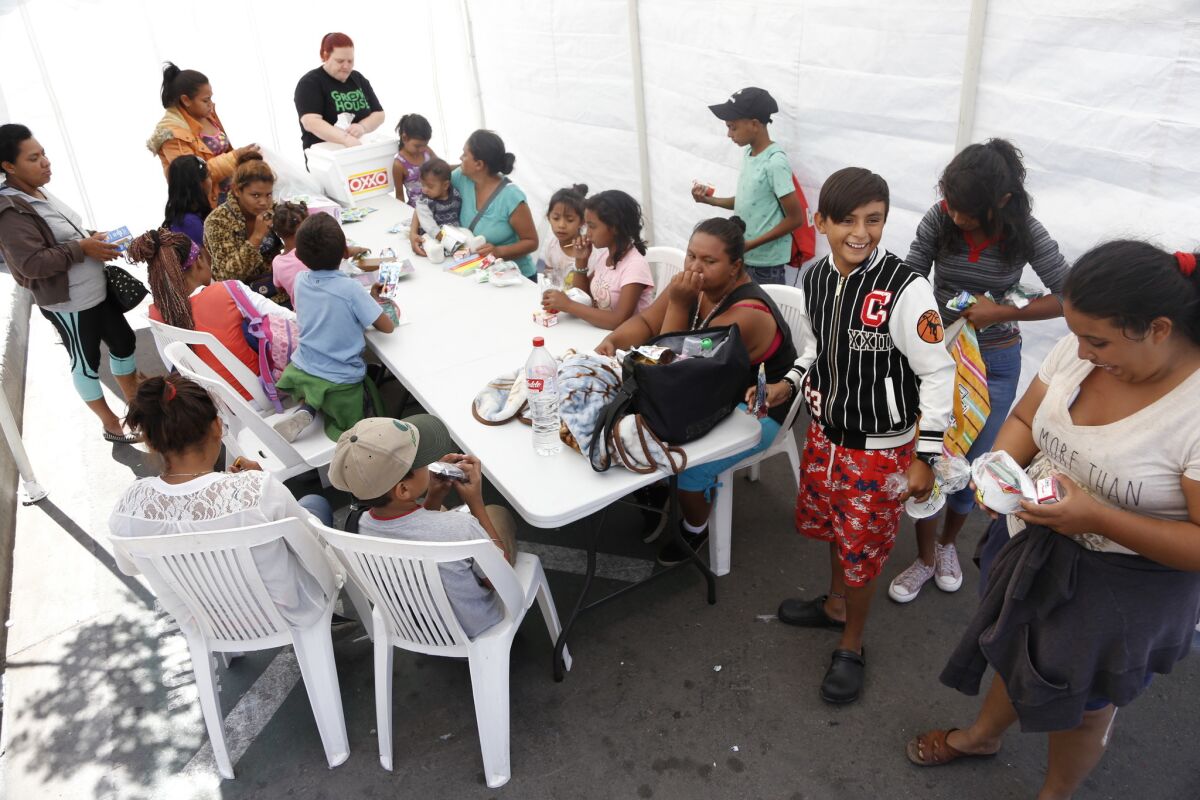 Migrants staying at a shelter in Tijuana's Zona Norte gather for lunch on Friday.