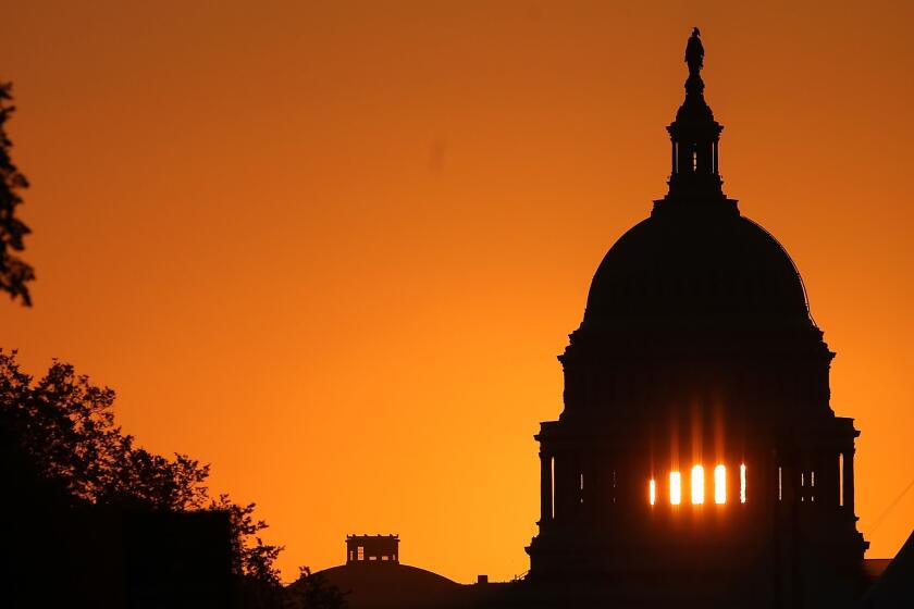 The early morning sun rises behind the U.S. Capitol building in Washington, D.C.