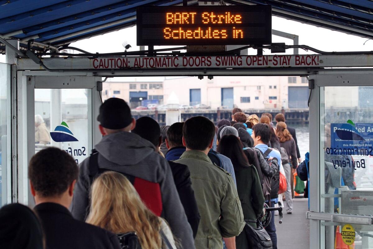 A poll released Friday found that Californian's view on labor unions has turned sour and that 47% of Californians don't believe public transit workers should be allowed to strike. Above, commuters prepare to board a ferry in October on the fourth day of a public transit strike in Oakland.