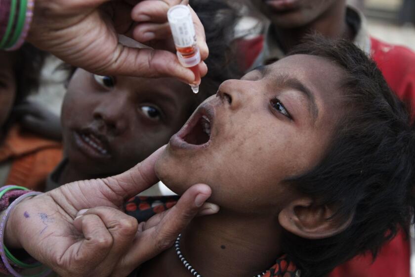 An Indian heath worker administers a drop of polio vaccine to a homeless child at a railway station during a polio eradication campaign in Allahabad, India, Sunday, Jan. 23, 2011. Every year India mobilizes more than two million health workers for an immunization day, visiting more than 200 million homes. (AP Photo/Rajesh Kumar Singh) @@*@@* HOY OUT, MASH OUT, TCN OUT @@*@@*