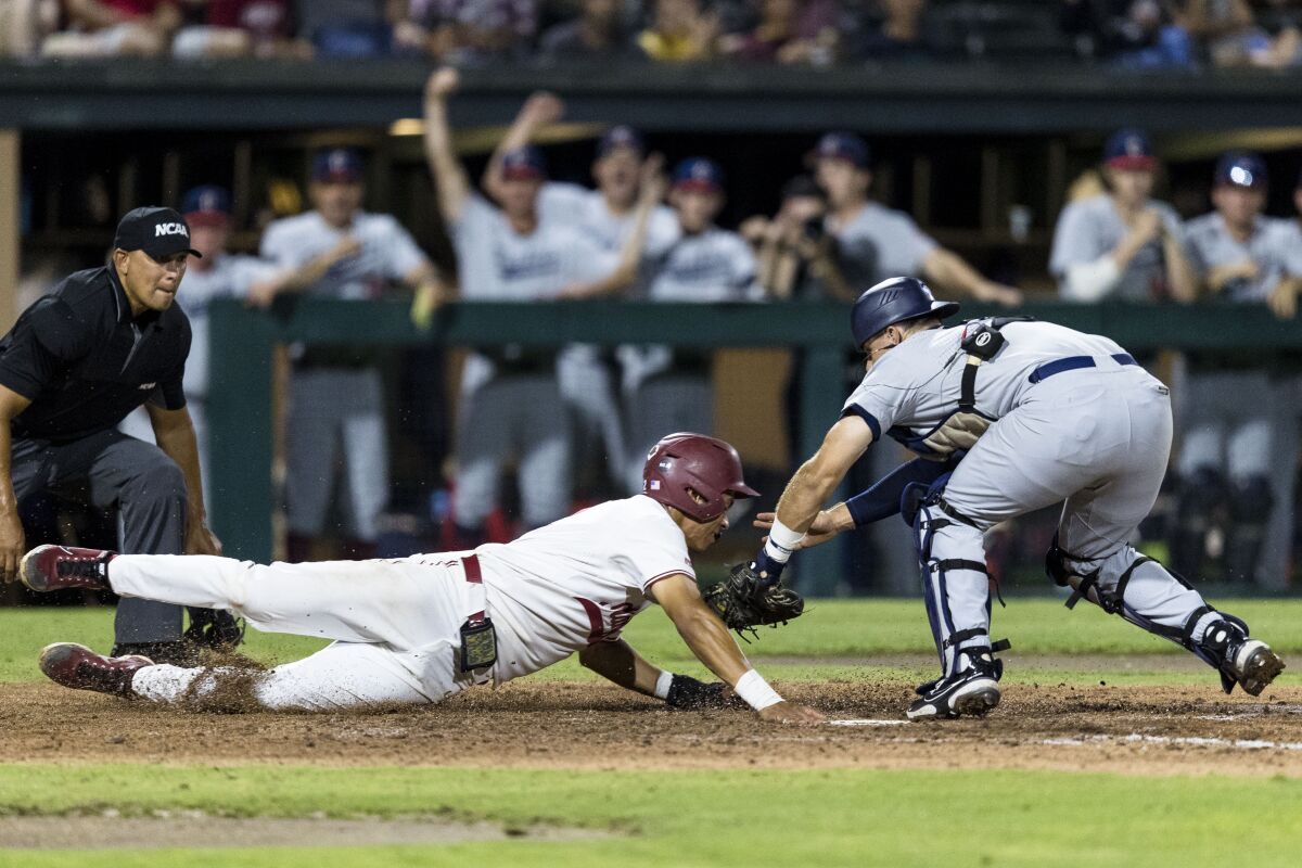 Connecticut catcher Matt Donlan, right, tags out Stanford's Drew Bowser during the fourth inning of an NCAA college baseball tournament super regional game Saturday, June 11, 2022, in Stanford, Calif. (AP Photo/John Hefti)