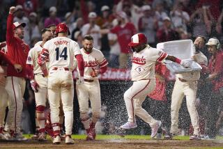 Willie Calhoun celebrates with teammates at home plate after hitting a home run against the Mariners at Angel Stadium.