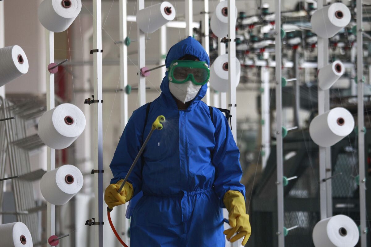 An employee of Songyo Knitwear Factory in Songyo district disinfects the work floor in Pyongyang, North Korea, Wednesday, May 18, 2022, after Kim Jong Un said Tuesday his party would treat the country's outbreak under the state emergency. North Korea said Wednesday more than a million people have already recovered from suspected COVID-19 just a week after disclosing an outbreak it appears to be trying to manage in isolation as global experts express deep concern about the public health threat. (AP Photo/Jon Chol Jin)