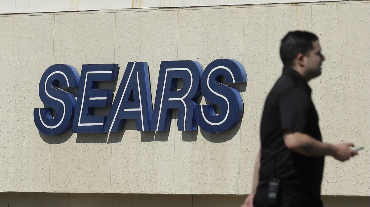 A man walks in front of a Sears sign in San Bruno, Calif., in March.