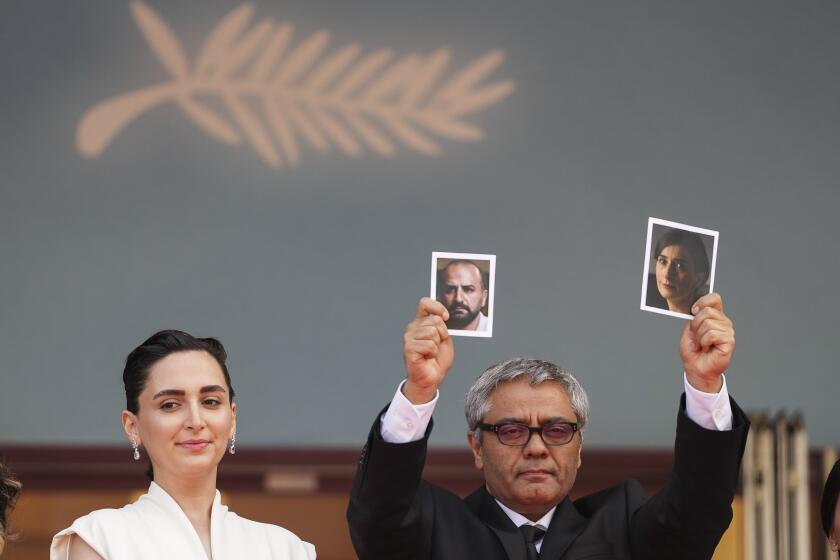 ADDING IDs OF PEOPLE IN PHOTOGRAPHS Director Mohammad Rasoulof holds up photographs of actors Soheila Golestani, right, and Missagh Zareh alongside Soheila Golestani, left, upon arrival at the premiere of the film 'The Seed of the Sacred Fig' at the 77th international film festival, Cannes, southern France, Friday, May 24, 2024. (Photo by Scott A Garfitt/Invision/AP)