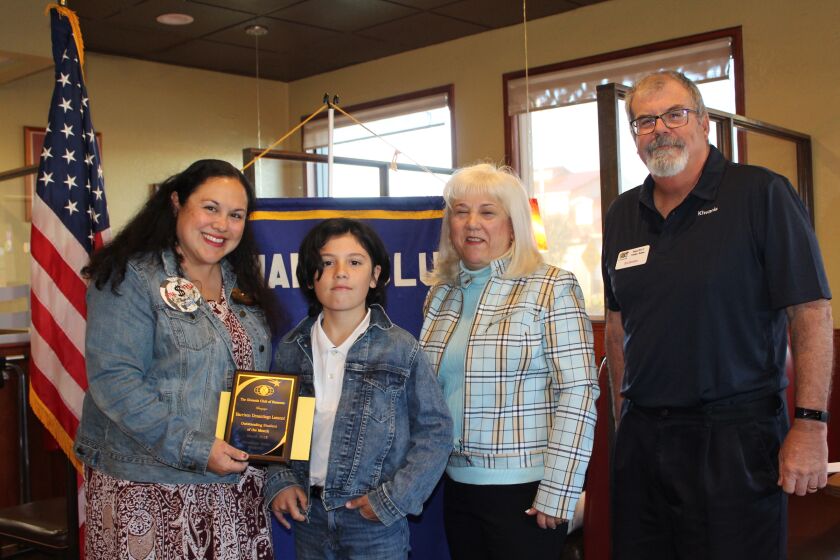 Tiffany Lynch of Kiwanis Club of Ramona presents Harrison Desantiago with his Outstanding Student of the Month plaque.